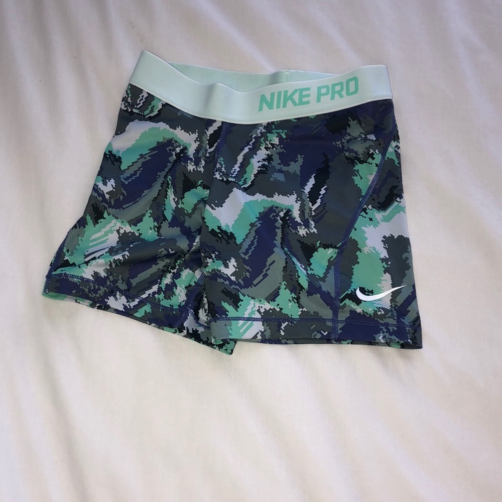 green and blue patterned nike pros